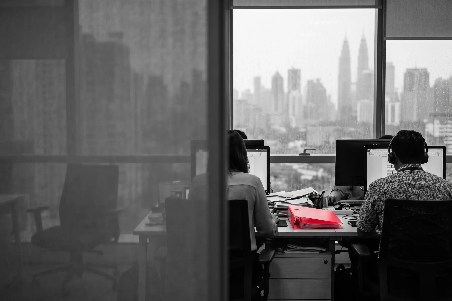 Two people seen from behind working at their desks