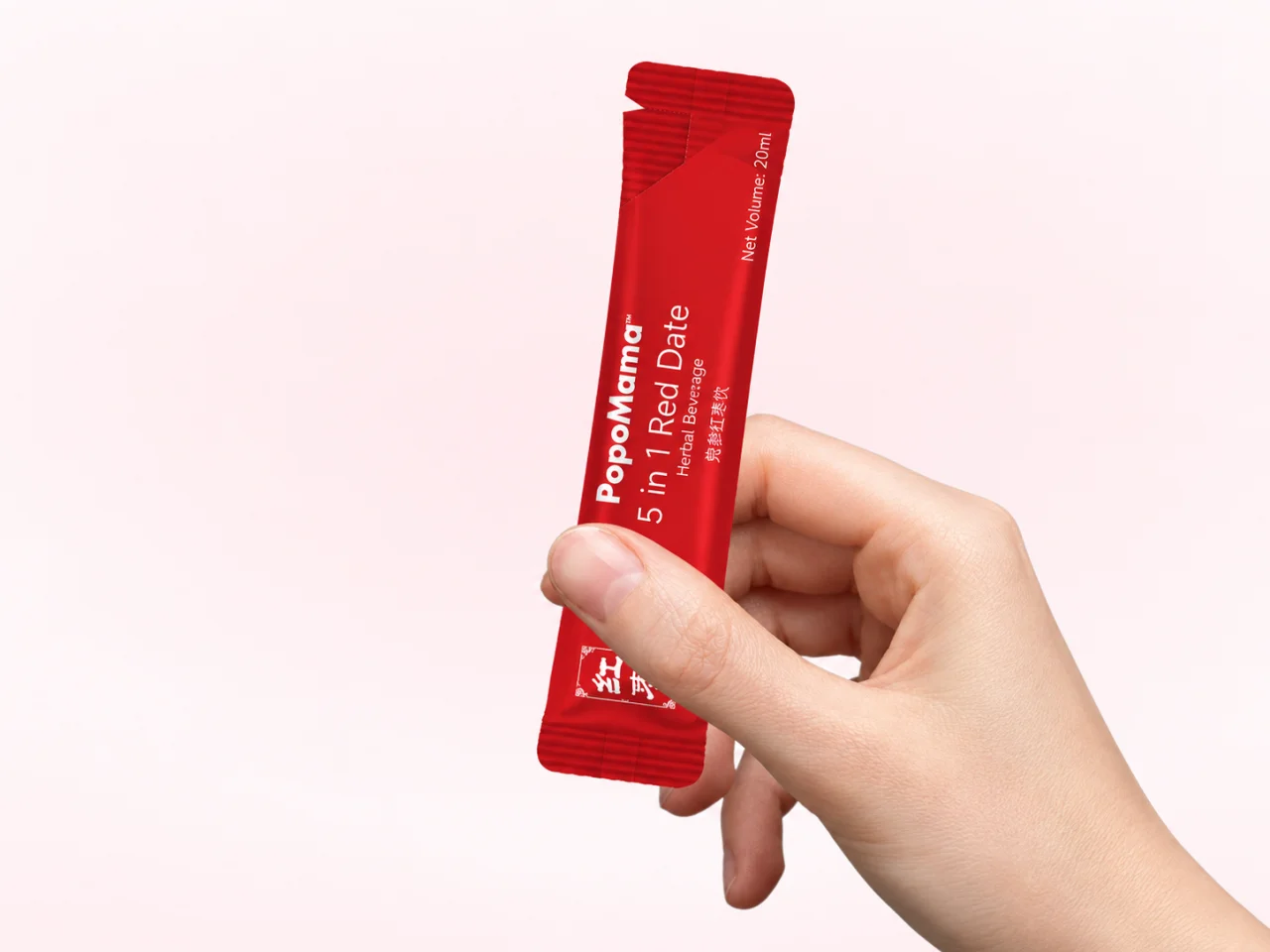 A PopoMama Red Date sachet held in one hand